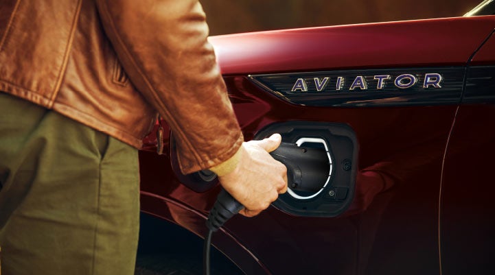A hand is shown plugging in the charger into the charging port of a 2021 Lincoln Aviator | Thornhill Lincoln in Chapmanville WV