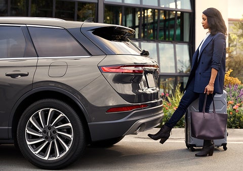 A woman with her hands full uses her foot to activate the available hands-free liftgate. | Thornhill Lincoln in Chapmanville WV