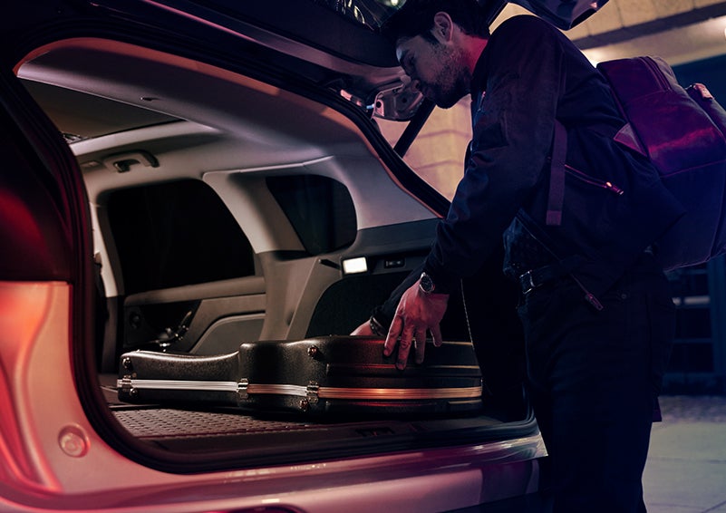 A man is shown loading cargo into the rear of a 2024 Lincoln Corsair® SUV with the second-row seats folded flat. | Thornhill Lincoln in Chapmanville WV